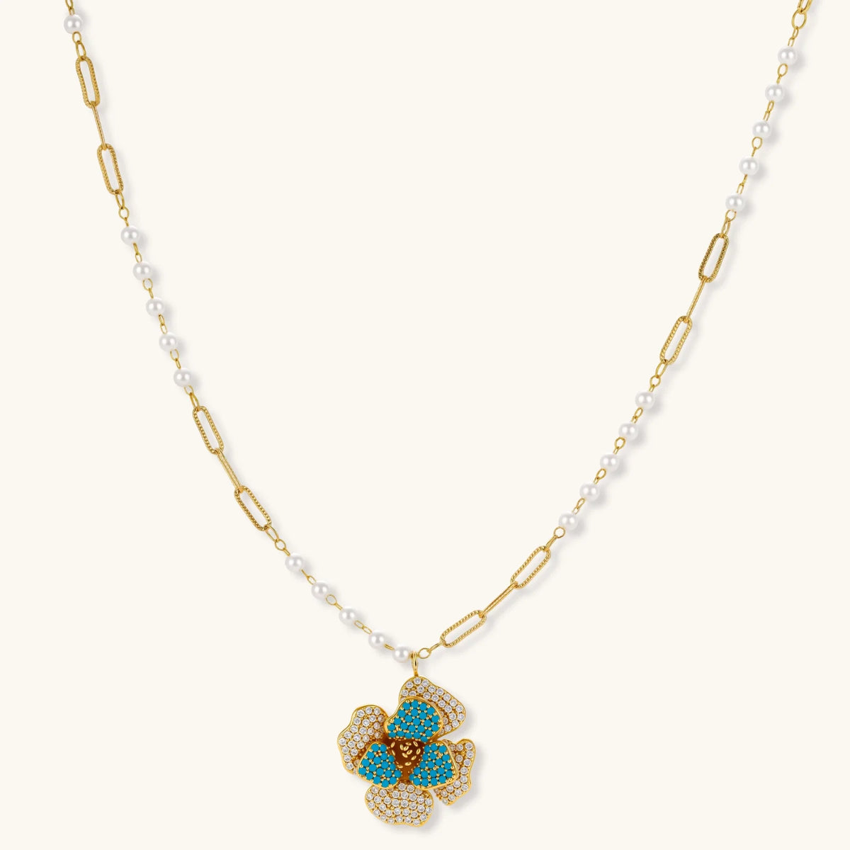 Gold-plated flower jewelry set with blue zirconia center petals and clear crystal outer petals on neutral background.