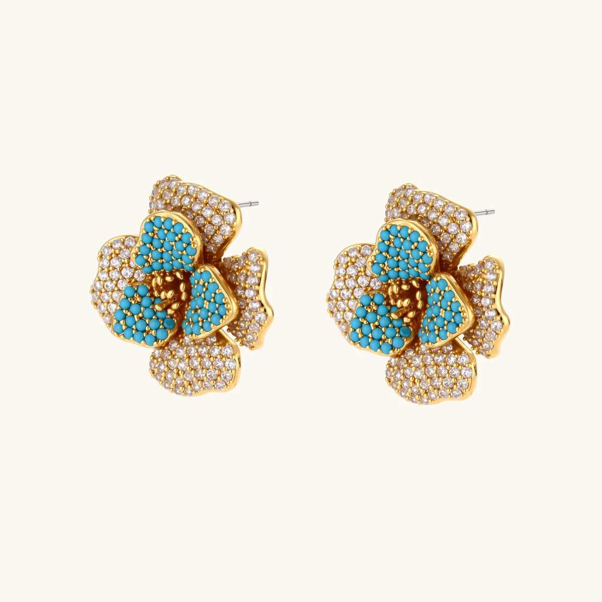 Gold-plated flower jewelry set with blue zirconia center petals and clear crystal outer petals on neutral background.