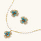 Gold-plated flower jewelry set with blue zirconia center petals and clear crystal outer petals on neutral background.