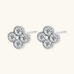 Dainty sterling silver quatrefoil stud earrings with four brilliant moissanite stones and center accent on white background.