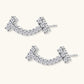 Curved sterling silver ear climbers with moissanite stones arranged in elegant arc shape on white background