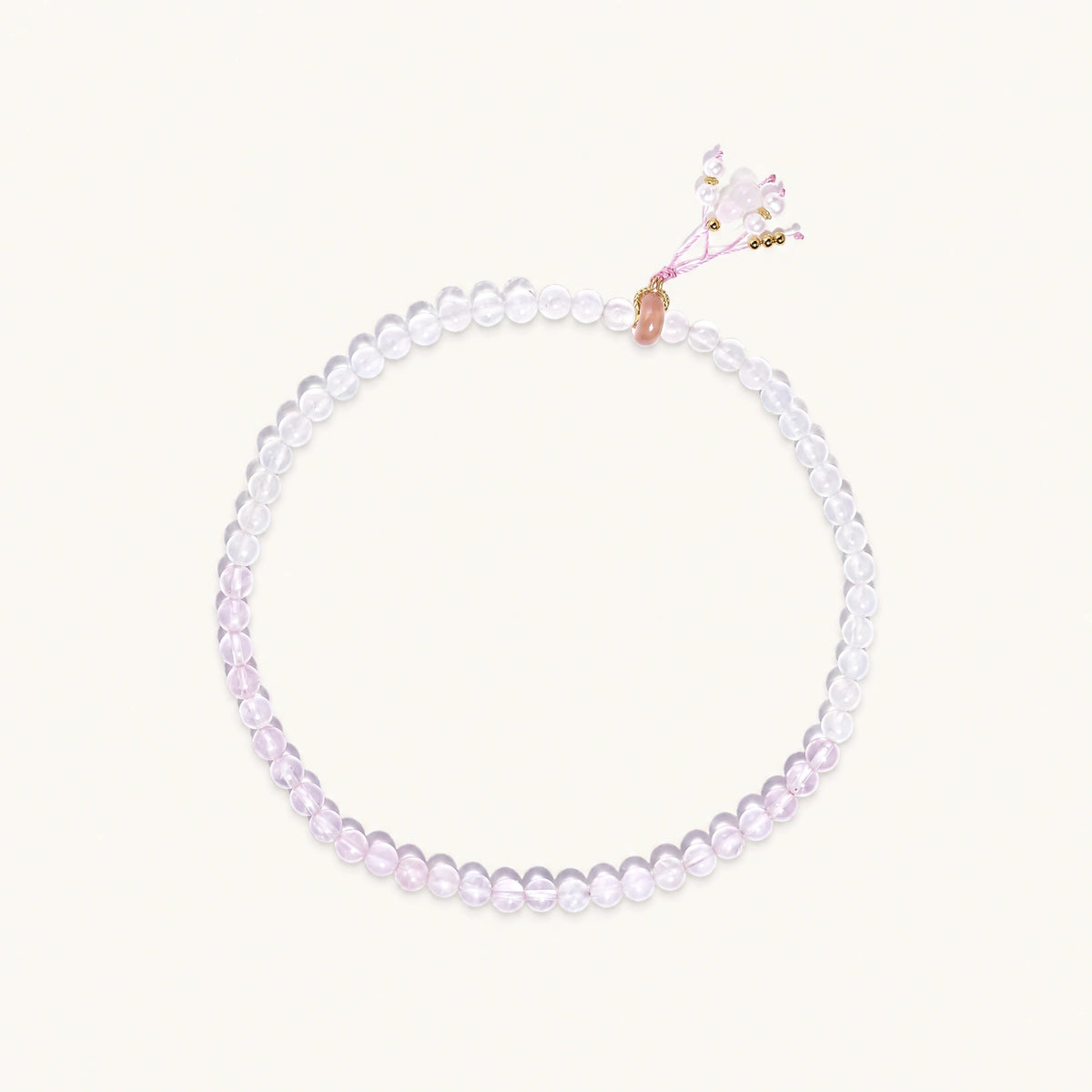 Double-wrap lavender beaded bracelet with rose quartz, pearls, gold vermeil charm and pink tassel on white background.