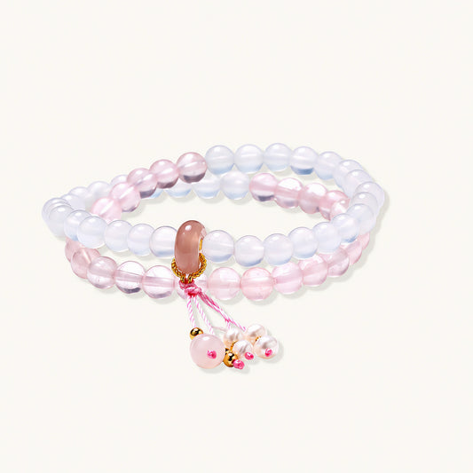 Double-wrap lavender beaded bracelet with rose quartz, pearls, gold vermeil charm and pink tassel on white background.