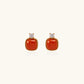 18K gold vermeil stud earrings with cushion-cut red agate stones and sparkling crystal accents on beige background