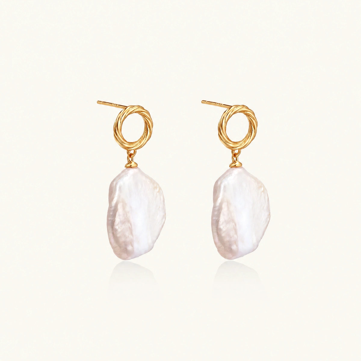 18K gold vermeil twisted circle studs with organic white baroque pearl drops on cream background