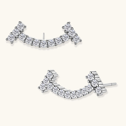 Curved sterling silver ear climbers with moissanite stones arranged in elegant arc shape on white background