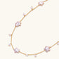 Gold vermeil chain with iridescent star-shaped baroque pearls and small round freshwater pearl drops on cream background.