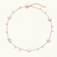 Gold vermeil chain with iridescent star-shaped baroque pearls and small round freshwater pearl drops on cream background.