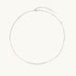 Delicate sterling silver chain necklace with small freshwater pearls arranged in a curved smile arc on cream background.