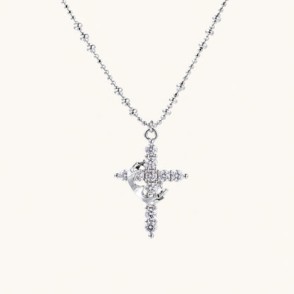 White gold-plated cross pendant adorned with sparkling zirconia stones and crescent moon accent on ball chain