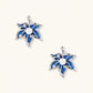 Pair of maple leaf stud earrings with blue denim fabric, a white bead center and zirconia accents in white gold plated eco-brass.