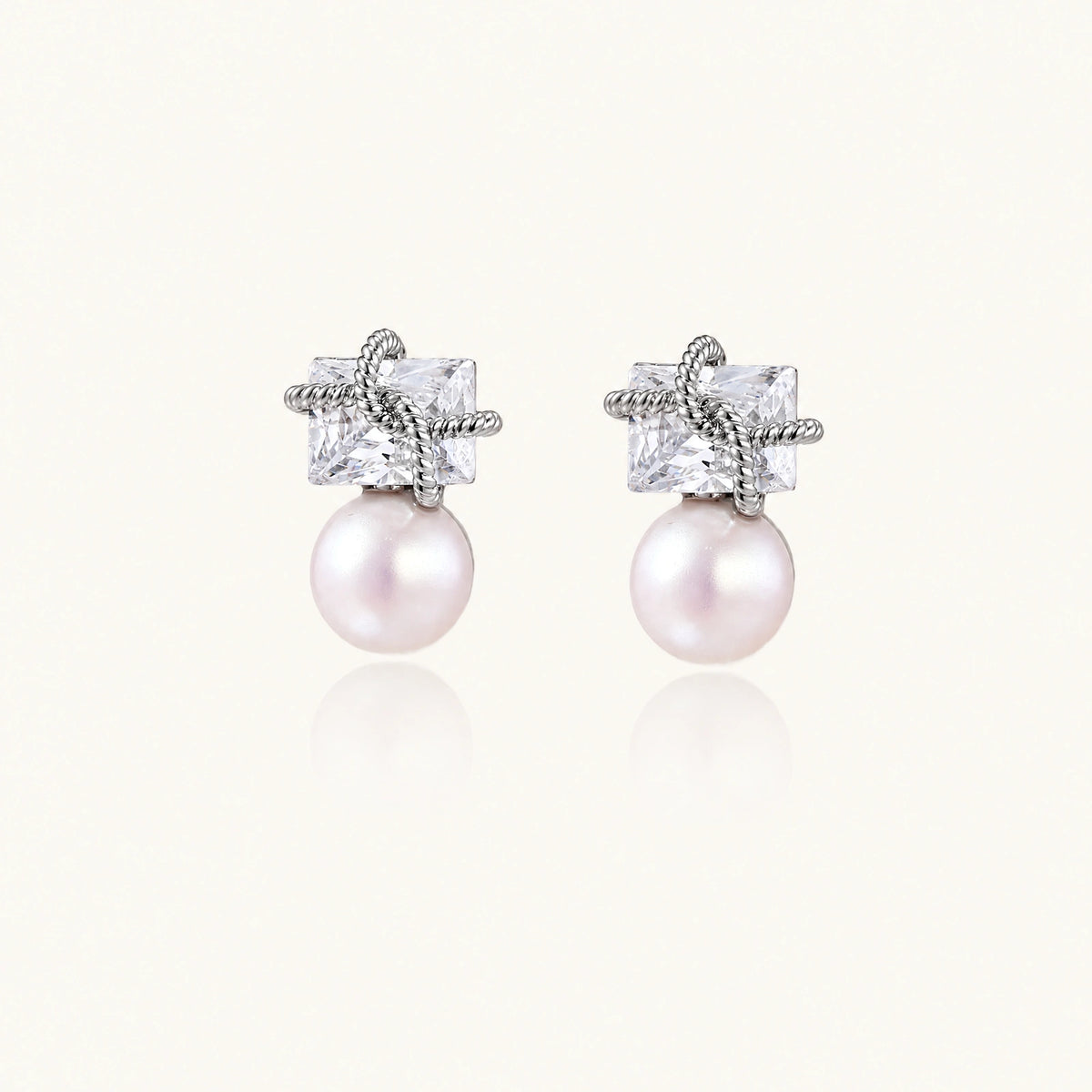 White gold stud earrings with square crystal stones in twisted frames and pink freshwater pearl drops below