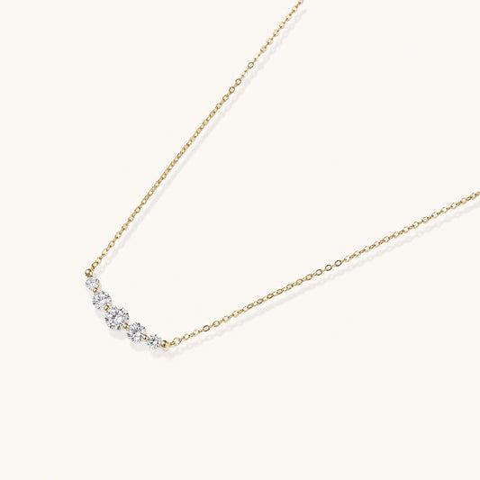Delicate 14K gold-plated necklace with five graduated zirconia stones arranged in a curved arc on fine chain