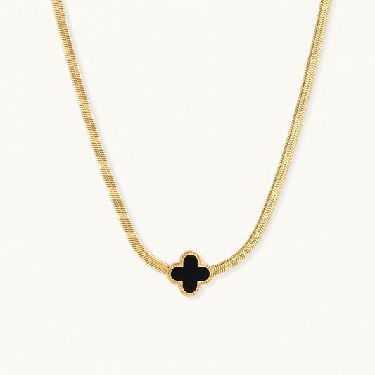 Dainty 18K gold-plated herringbone chain necklace with black enamel quatrefoil clover pendant on white background