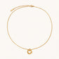 Delicate gold-plated necklace with three interlocking circle rings forming a minimalist knot pendant on cream background