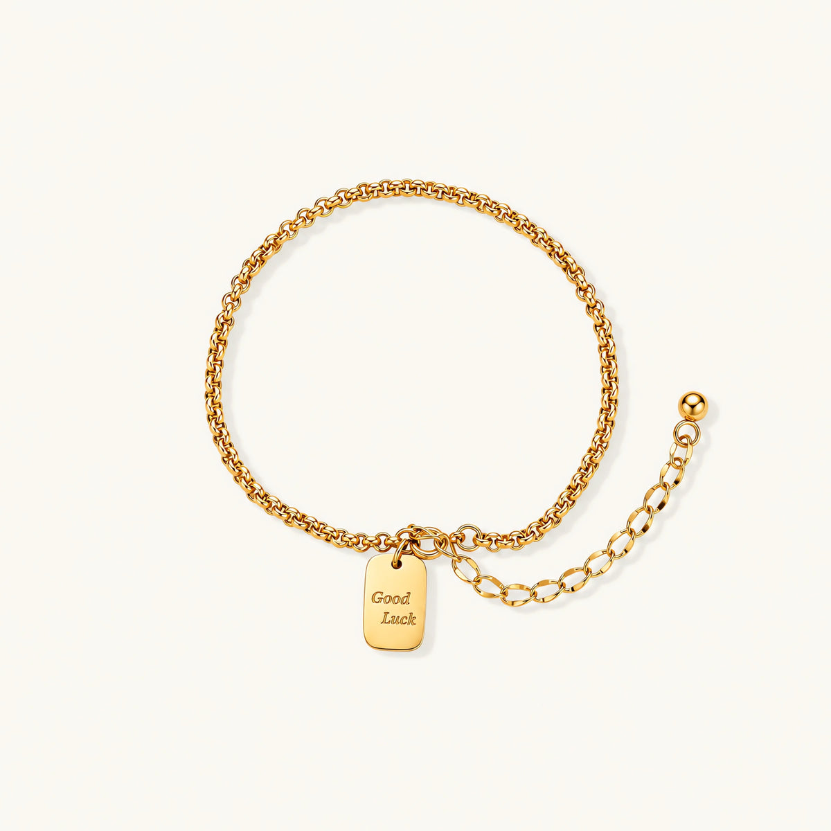 Delicate 18K gold-plated chain bracelet with Good Luck engraved rectangular pendant on cream background