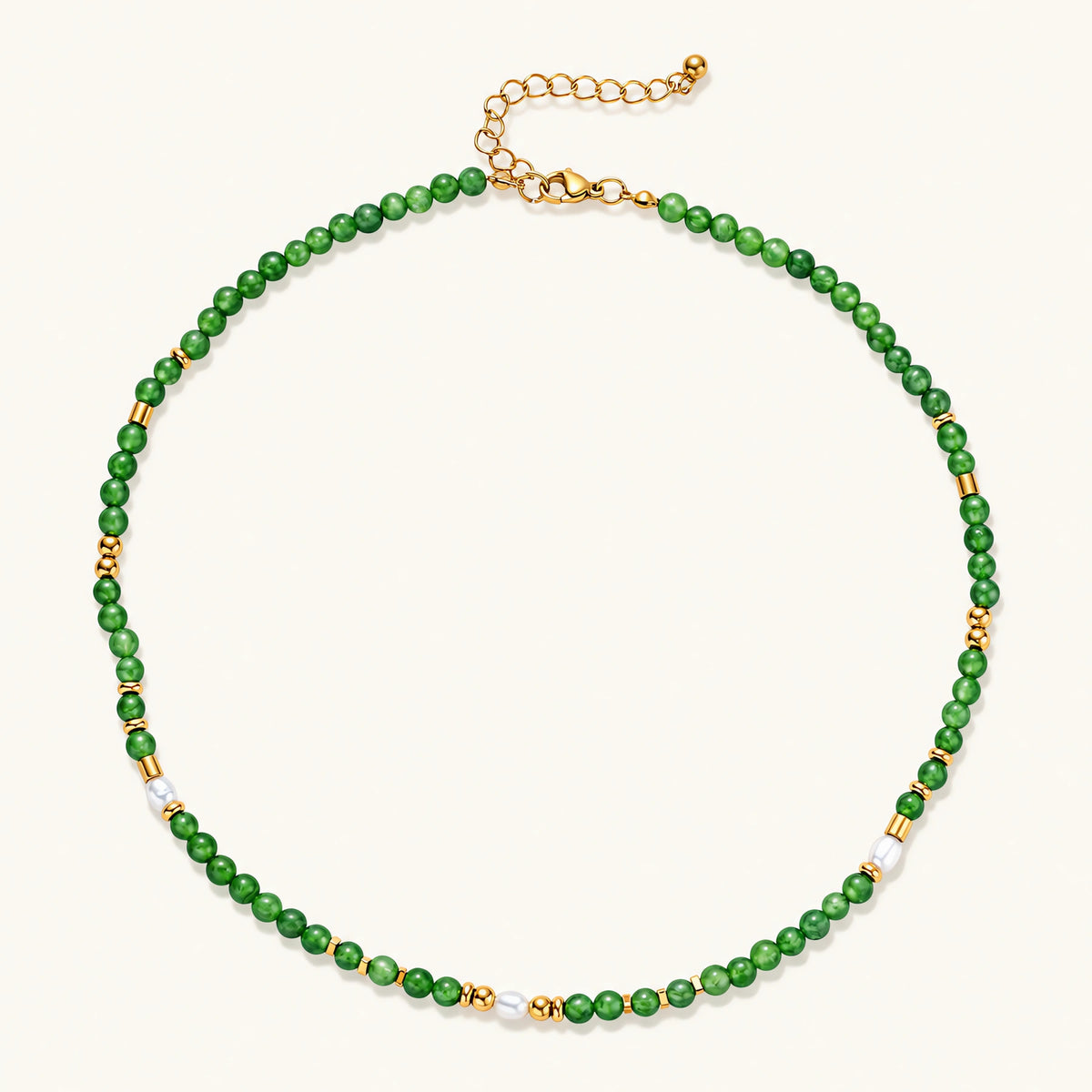 Layered necklace with green stone beads, gold spacers, white accents, and protective eye pendant on cream background.