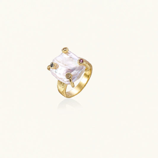 Gold ring with large iridescent baroque pearl and four colored gemstones on textured band