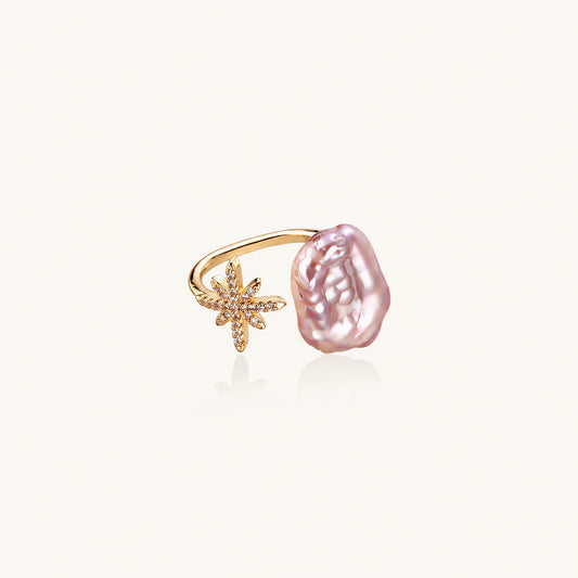 Adjustable gold ring with pink baroque freshwater pearl and crystal-studded star charm on white background
