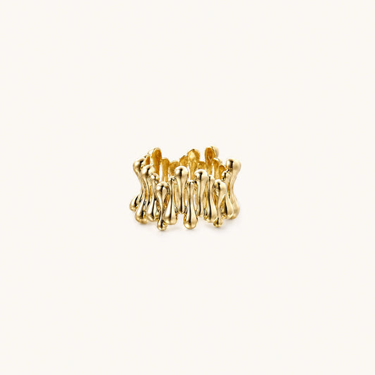 Gold-plated brass ring with sculptural petal-like elements in a wide band design on beige background