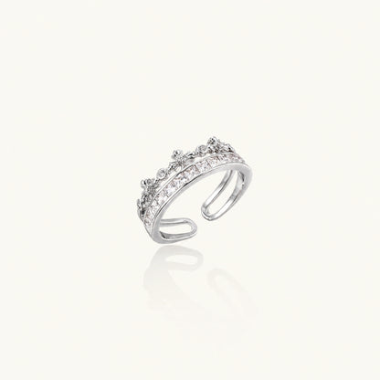 Silver-toned adjustable crown ring with channel-set square zirconia stones and delicate floral details on white background