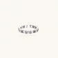 White gold plated ring with architectural lattice design and zirconia accents on cream background