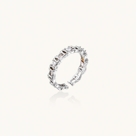 White gold plated ring with architectural lattice design and zirconia accents on cream background