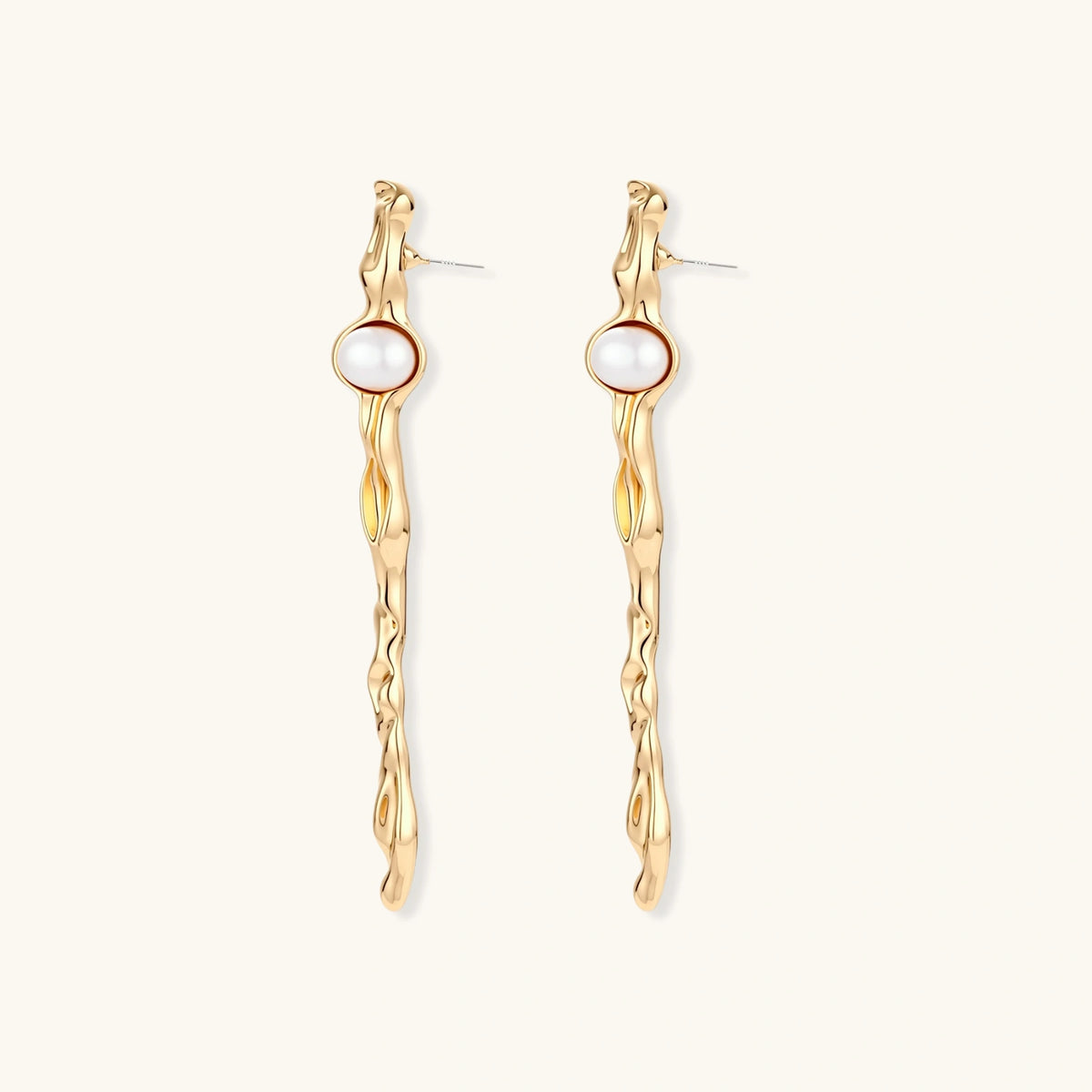 Long gold twisted sculptural earrings with round pearls, featuring flowing organic design on cream background