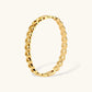 Gold 18K plated stainless steel bangle with continuous open heart links, high-polish finish, on white background.